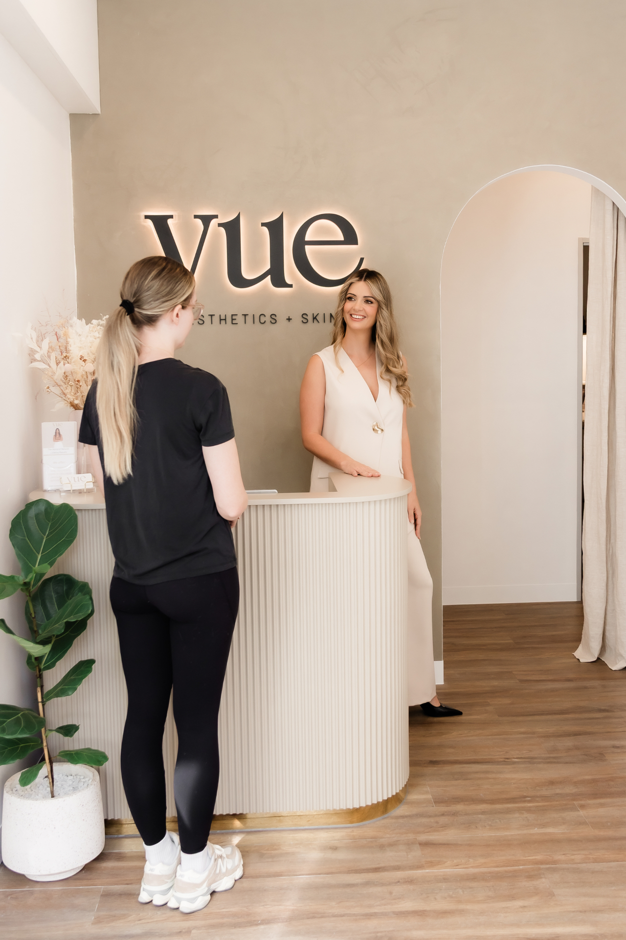 Vue Aesthetics + Skin reception, North Lakes — warm neutral interior with signature wall
